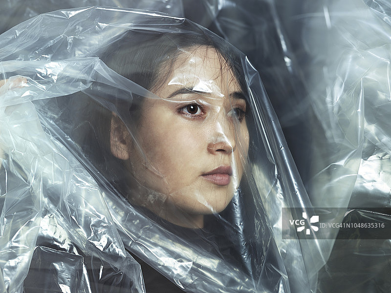 年轻女人透过塑料看图片素材