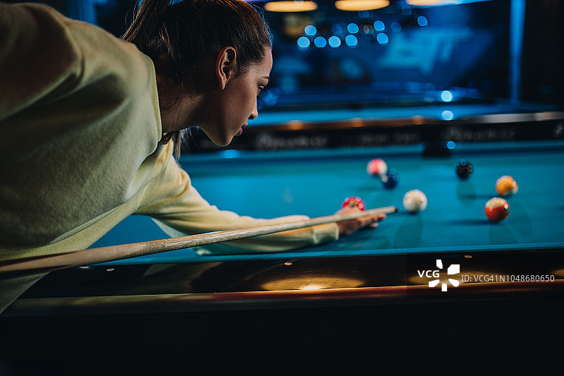 年轻女子在台球厅专心打台球图片素材