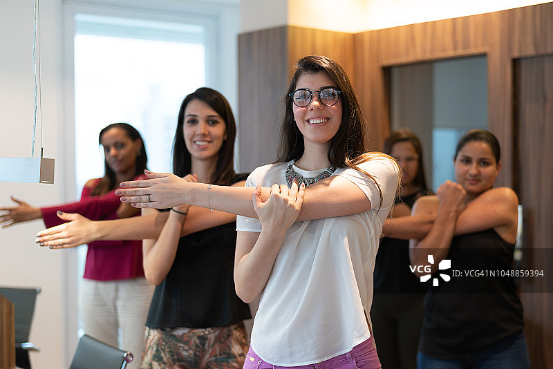 商务人士在办公室伸展身体图片素材