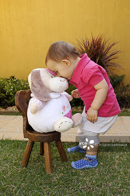 小女孩和她的毛绒玩具狗玩耍图片素材