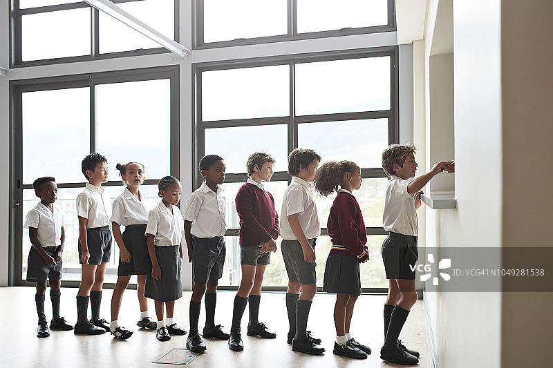 小学生在食堂排队等候午餐图片素材