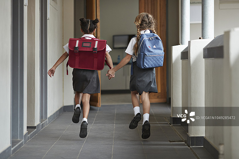 女学生手牵手在学校的岛上奔跑欢笑图片素材