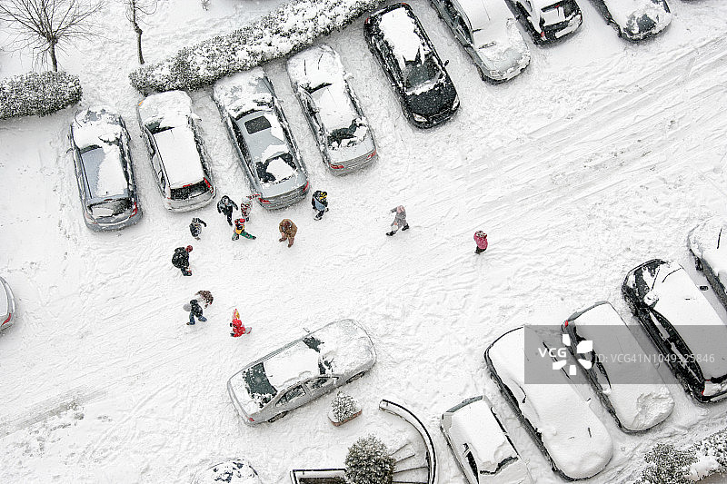 一群孩子在雪地街道上玩耍的高角度视图图片素材