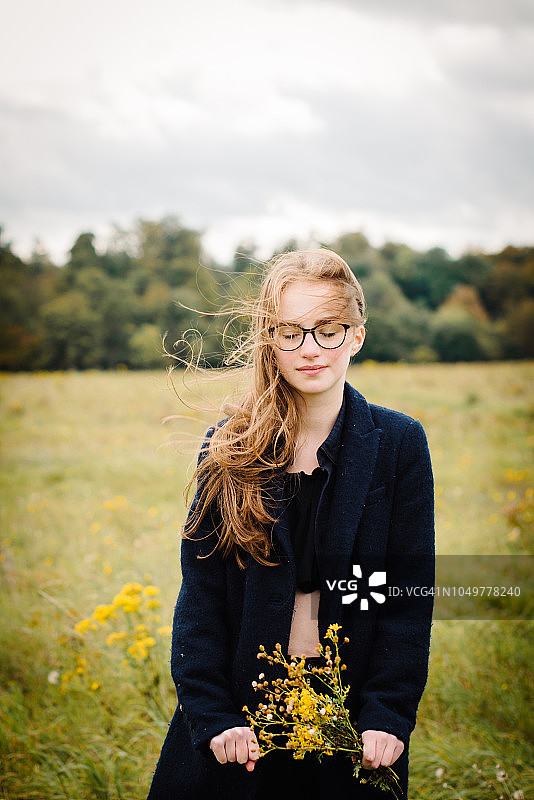 在田野里手捧鲜花的少女图片素材