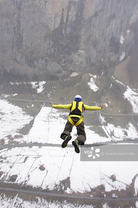 在瑞士阿尔卑斯山脉悬崖上进行低空跳伞图片素材