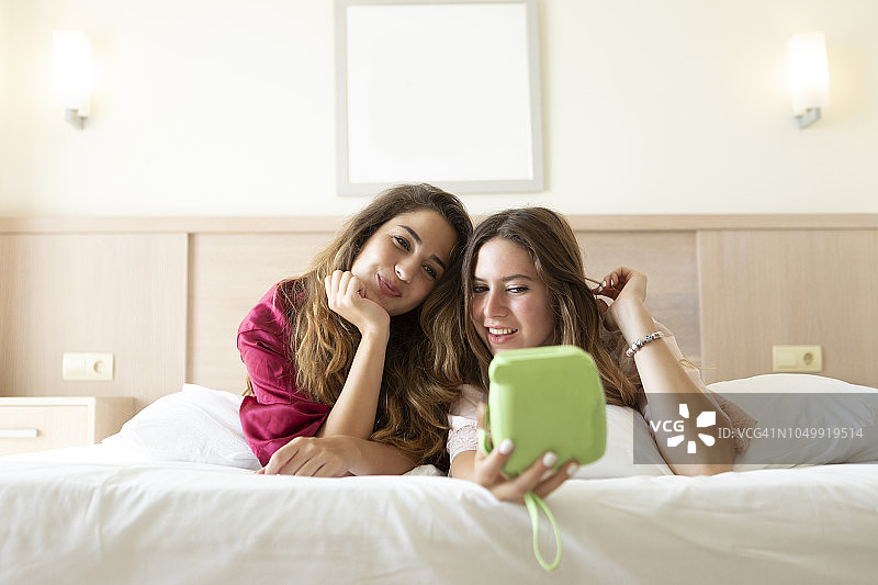 躺在床上自拍的两个微笑的女人图片素材