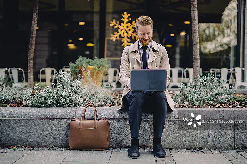 面带微笑的商人在街边工作图片素材