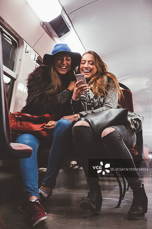 朋友们在地铁上发短信图片素材
