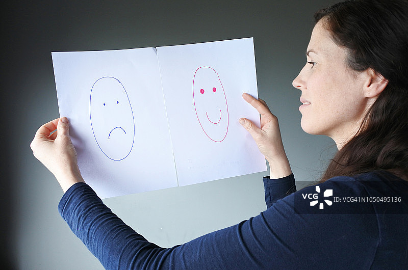 中年女人在幸福和悲伤之间做出选择图片素材
