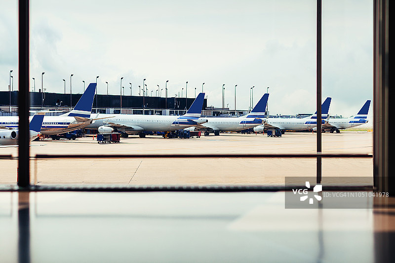 机场舷窗外停机坪上的飞机队列图片素材