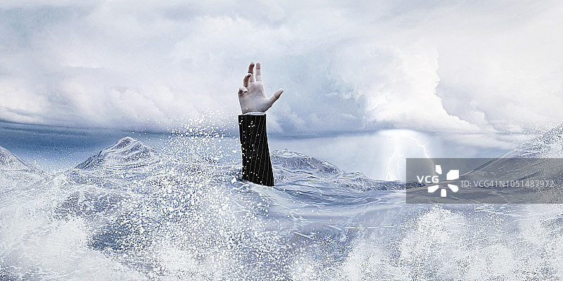 商人在波涛汹涌的海中举手图片素材
