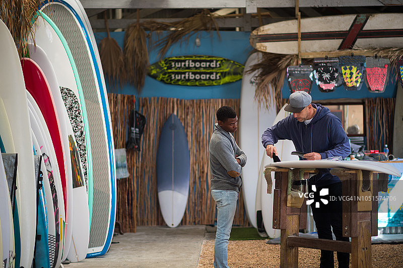在冲浪用品店做销售的小企业主图片素材