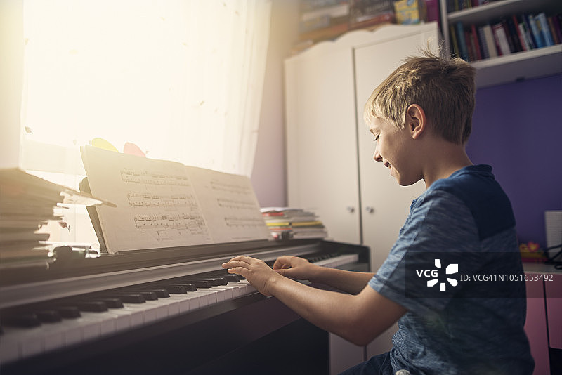 练习现代数码钢琴的小男孩图片素材