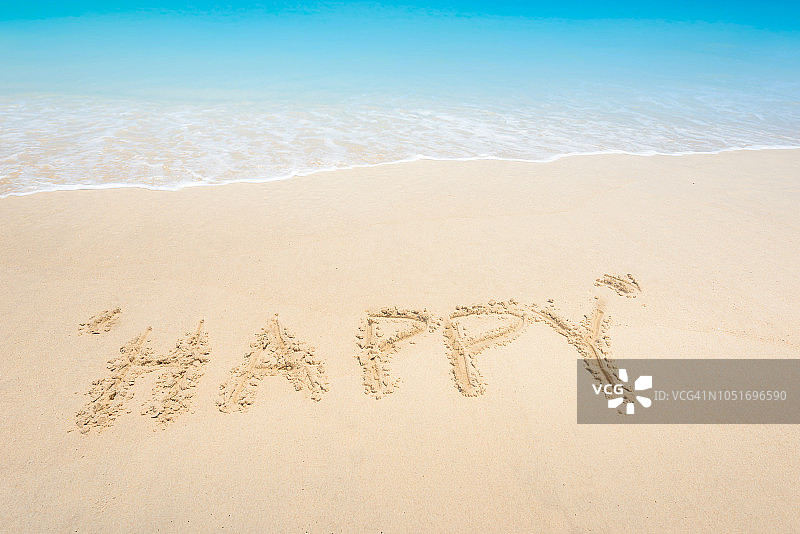 热带沙滩上用沙子写成的“快乐”字样图片素材