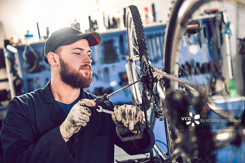 用螺丝刀修理自行车链条图片素材