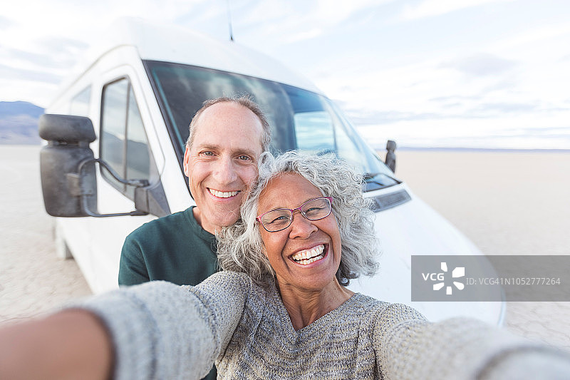 老年夫妇在穿越沙漠的公路旅行中自拍！图片素材
