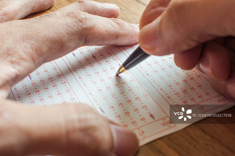 手填写彩票表格特写图片素材