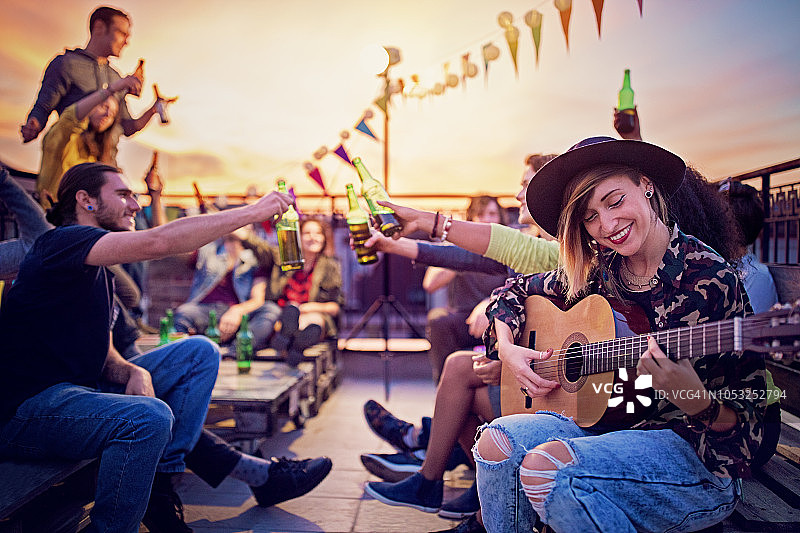 朋友们在屋顶露台上举办音乐会庆祝图片素材