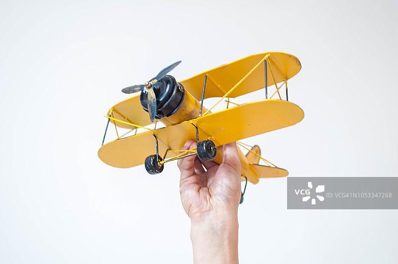 手持黄色复古飞机模型图片素材