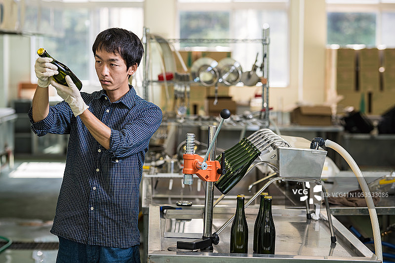 在小型精酿啤酒厂检查最终产品的中年男人图片素材