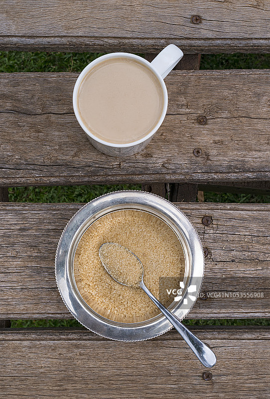 木桌上的热饮和带勺子的糖碗俯视图图片素材