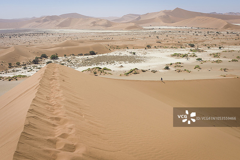 徒步者攀登纳米布-诺克卢夫国家公园的陡峭沙丘图片素材