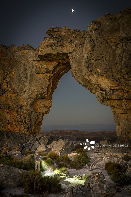 男人在南非西开普省锡德伯格荒野区的沃尔夫伯格拱门营地用手电筒探险图片素材