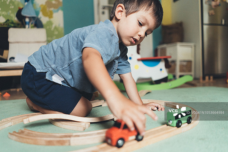 可爱的小男孩玩木制火车图片素材