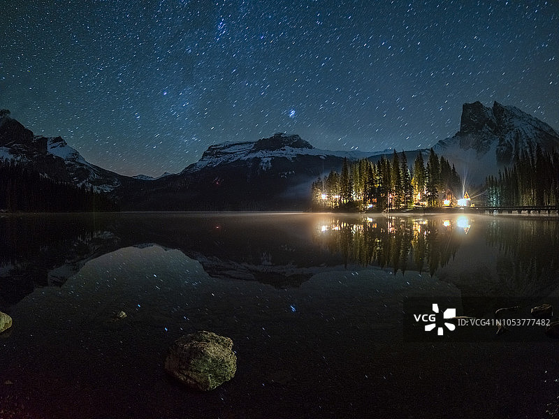 银河下小屋照明的祖母绿湖图片素材
