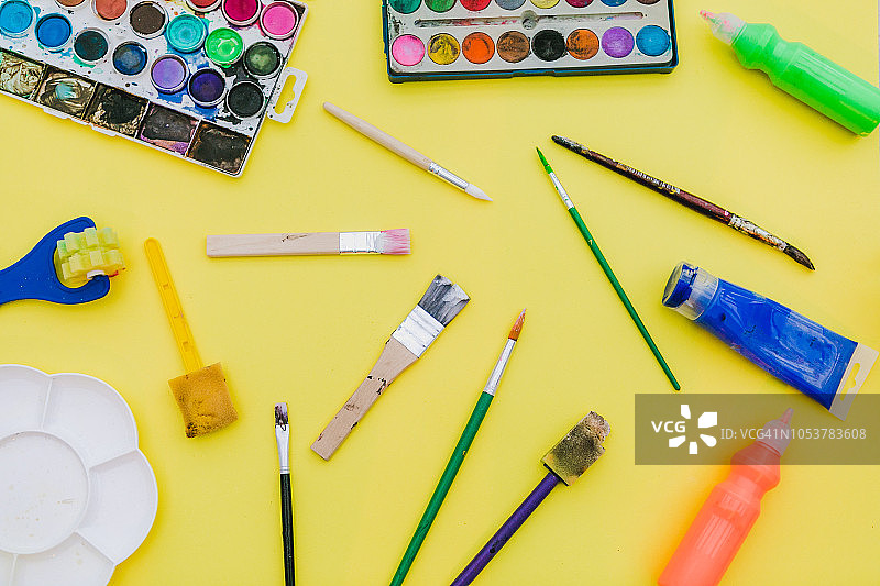艺术家工作室黄色桌上的彩色颜料照片图片素材