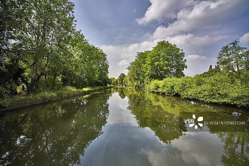 运河水中宁静而田园诗般的倒影。在夏日的午后，很难相信这里离伦敦市中心只有几英里图片素材