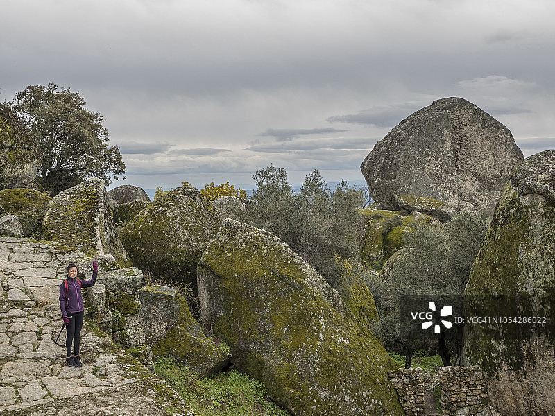 在花岗岩景观中摆姿势的徒步女性图片素材