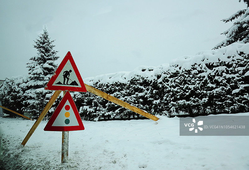 在积雪的道路上，男人在施工的路标图片素材