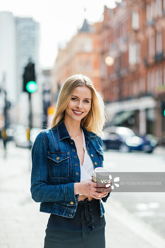 在英国伦敦等出租车的金发女人图片素材