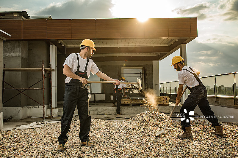 在建筑工地合作铲土的工人图片素材
