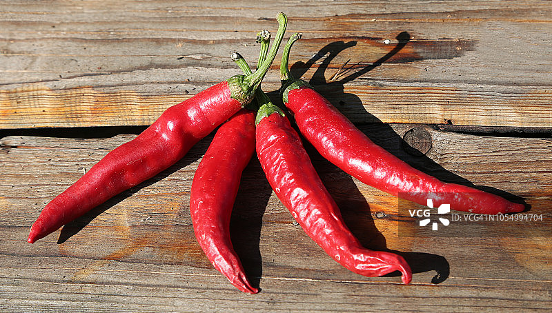 四根辛辣红辣椒在桌上图片素材