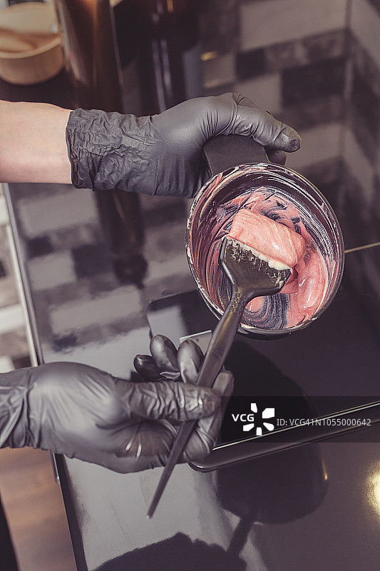 发型师在容器中准备染发剂图片素材