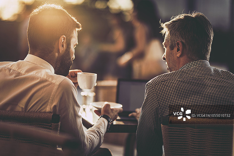 在咖啡馆工作的两位商人背影图片素材