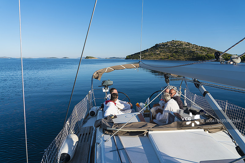 五位男士在船上交谈，其中两位是老年人，享受航海图片素材
