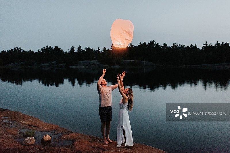 情侣在加拿大阿尔冈金公园湖边放天灯图片素材