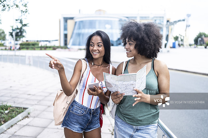 女性朋友在车站使用地图图片素材