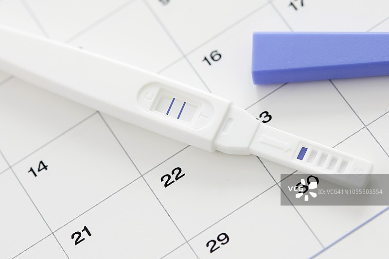 显示阳性结果的验孕棒和日历图片素材
