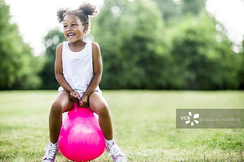 女孩在充气跳跳球上玩耍图片素材