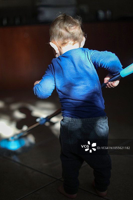 男婴在家玩拖把图片素材