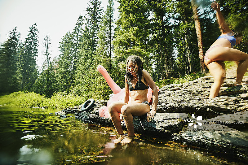 微笑的女人在夏日午后准备与朋友一起跳入河中图片素材
