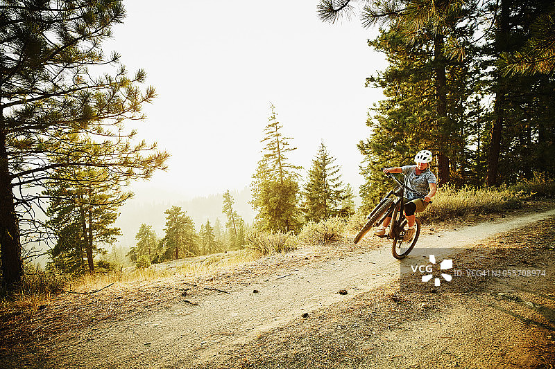 夏日傍晚女骑手在森林公路骑行图片素材