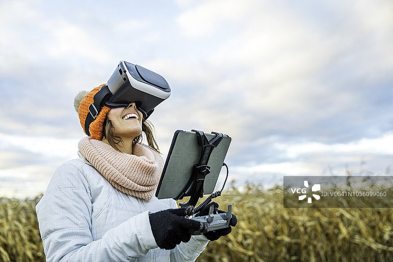 使用平板电脑和VR眼镜操控无人机的女飞行员图片素材