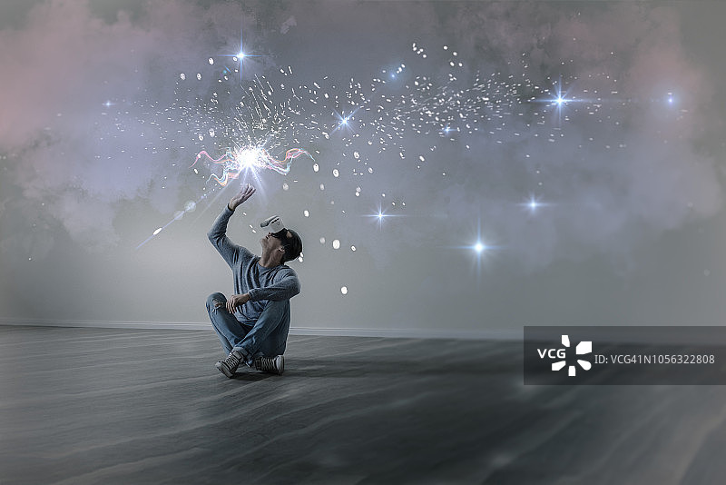 在空荡的公寓里使用VR眼镜的年轻男人图片素材