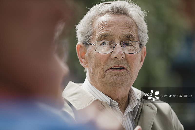 和朋友交谈的老年男人图片素材