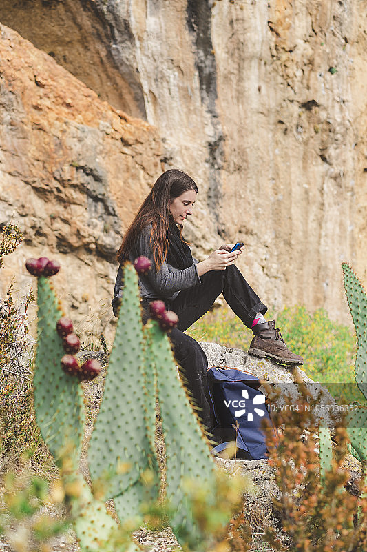 西班牙阿尔克萨尔，使用智能手机的年轻女子图片素材